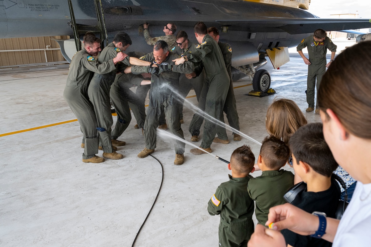 Col. Alfred Rosales, 49th Wing deputy commander, is sprayed with water after his fini-flight at Holloman Air Force Base, N.M., May 8, 2025. The tradition of getting sprayed with water, also known as a water salute, is a tradition that acknowledges the service member’s dedication and service. (U.S. Air Force photo by Senior Airman Nicholas Paczkowski)
