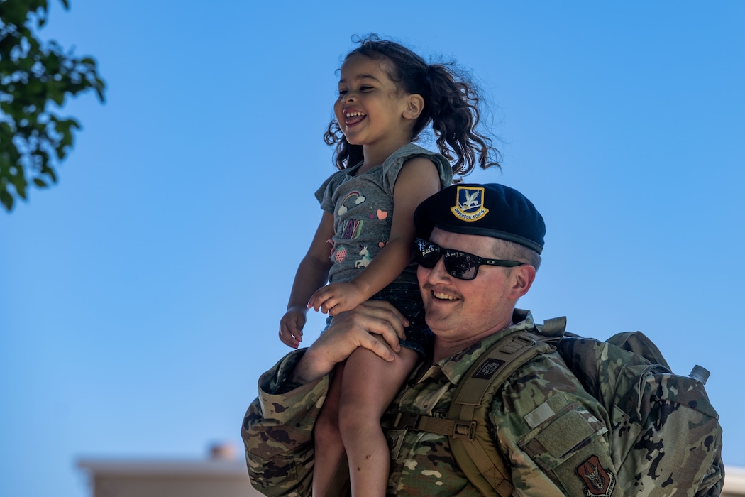 Little girl on Airman's shoulder