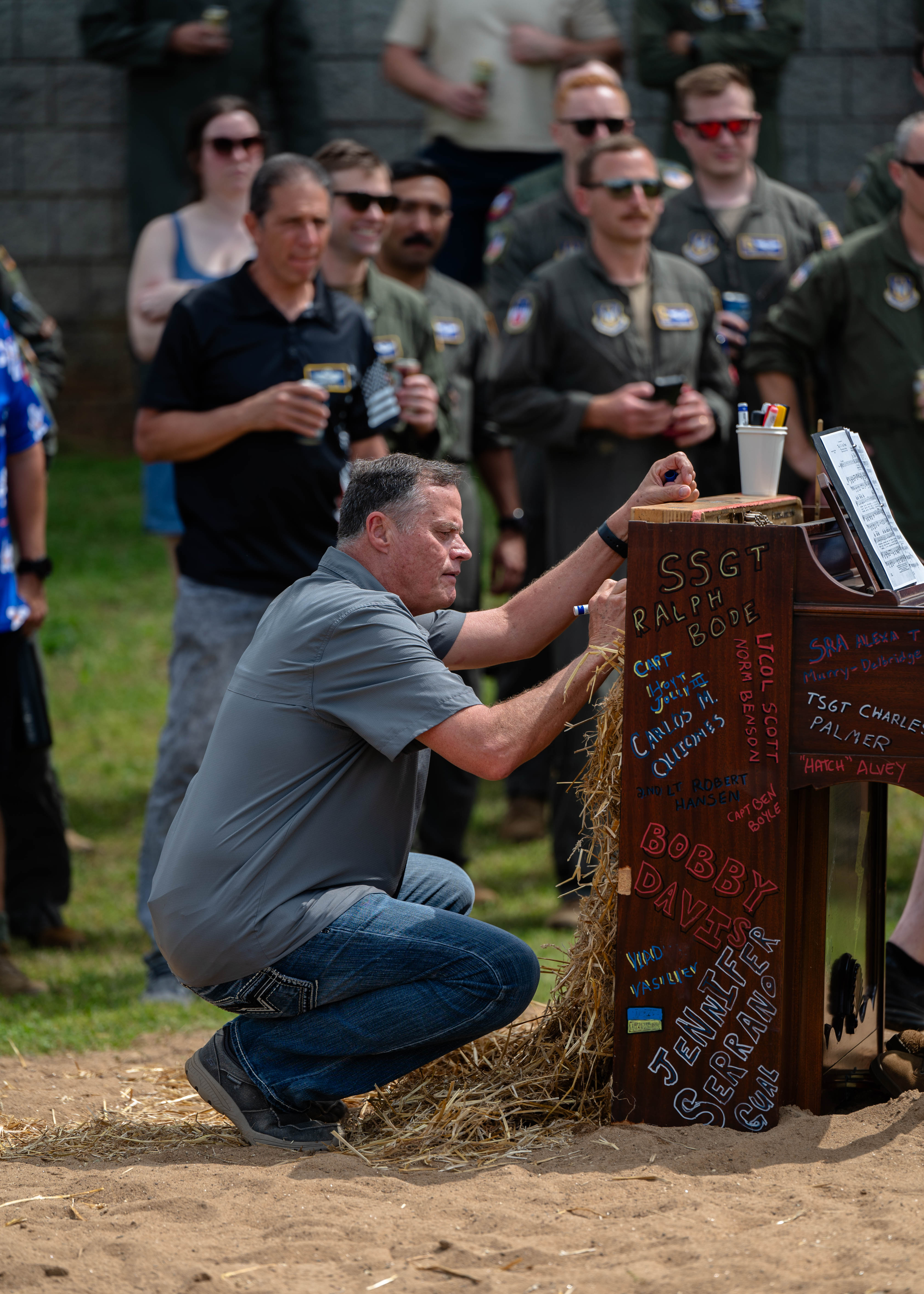 A name is added to a piano before its ceremonial burning at Dobbins Air Reserve Base, Ga., April 5, 2025. The event, attended by members of the 94th Airlift Wing, commemorates fallen Airmen through a historic aviation ritual. (U.S. Air Force photo by Master Sgt. Miles Wilson)