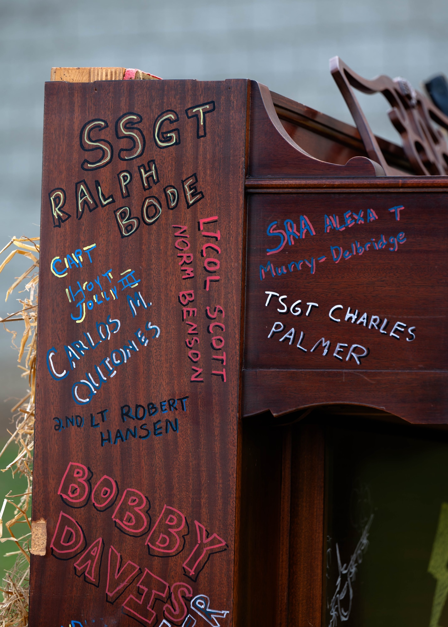 A piano inscribed with the names of deceased Airmen burns during a ceremony