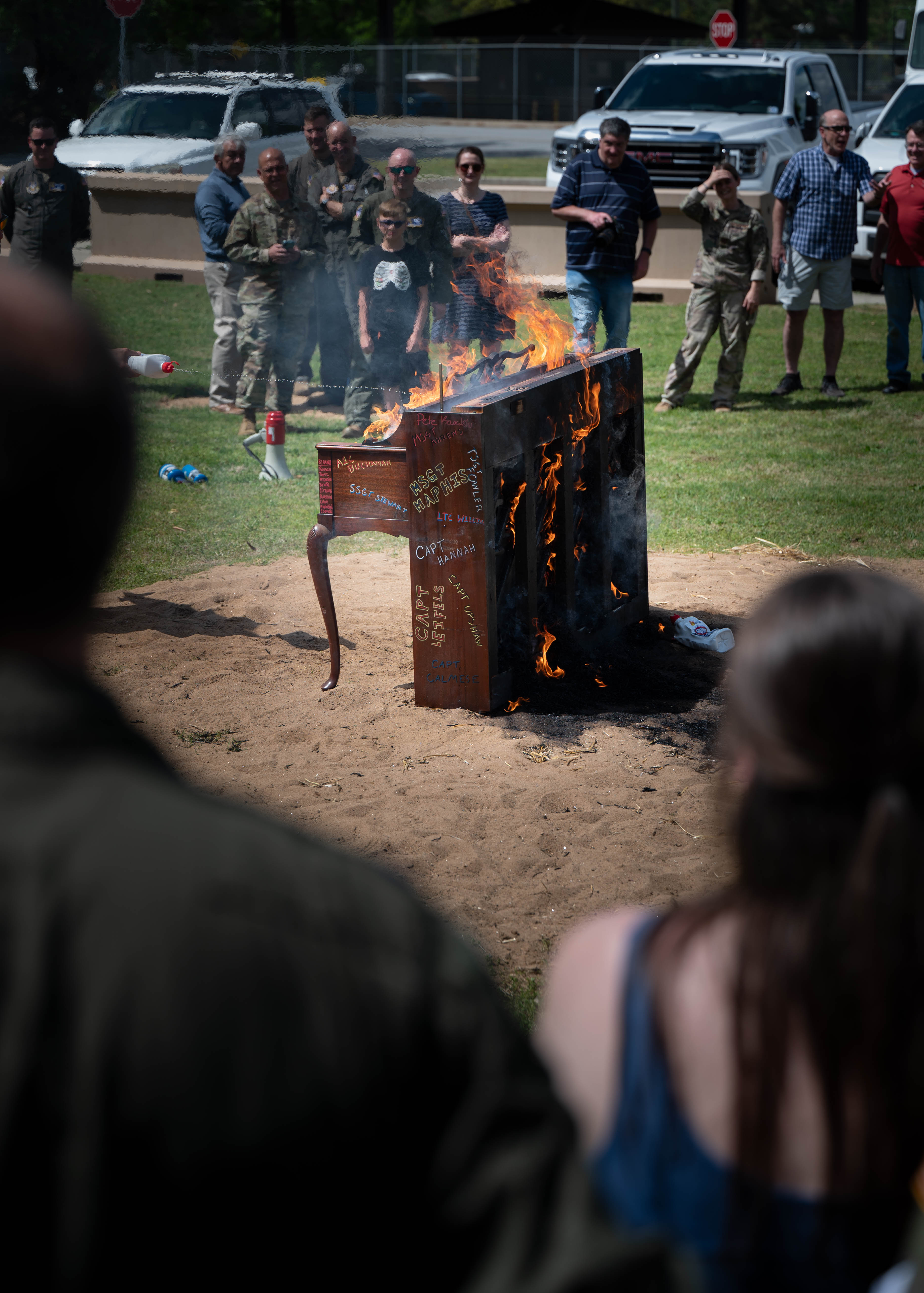 Guests and Airmen from the 700th Airlift Squadron observe a piano burning ceremony at Dobbins Air Reserve Base, Ga., April 5, 2025. The event, a tribute to fallen Airmen, continues a tradition rooted in aviation history to foster camaraderie and remembrance. (U.S. Air Force photo by Master Sgt. Miles Wilson)