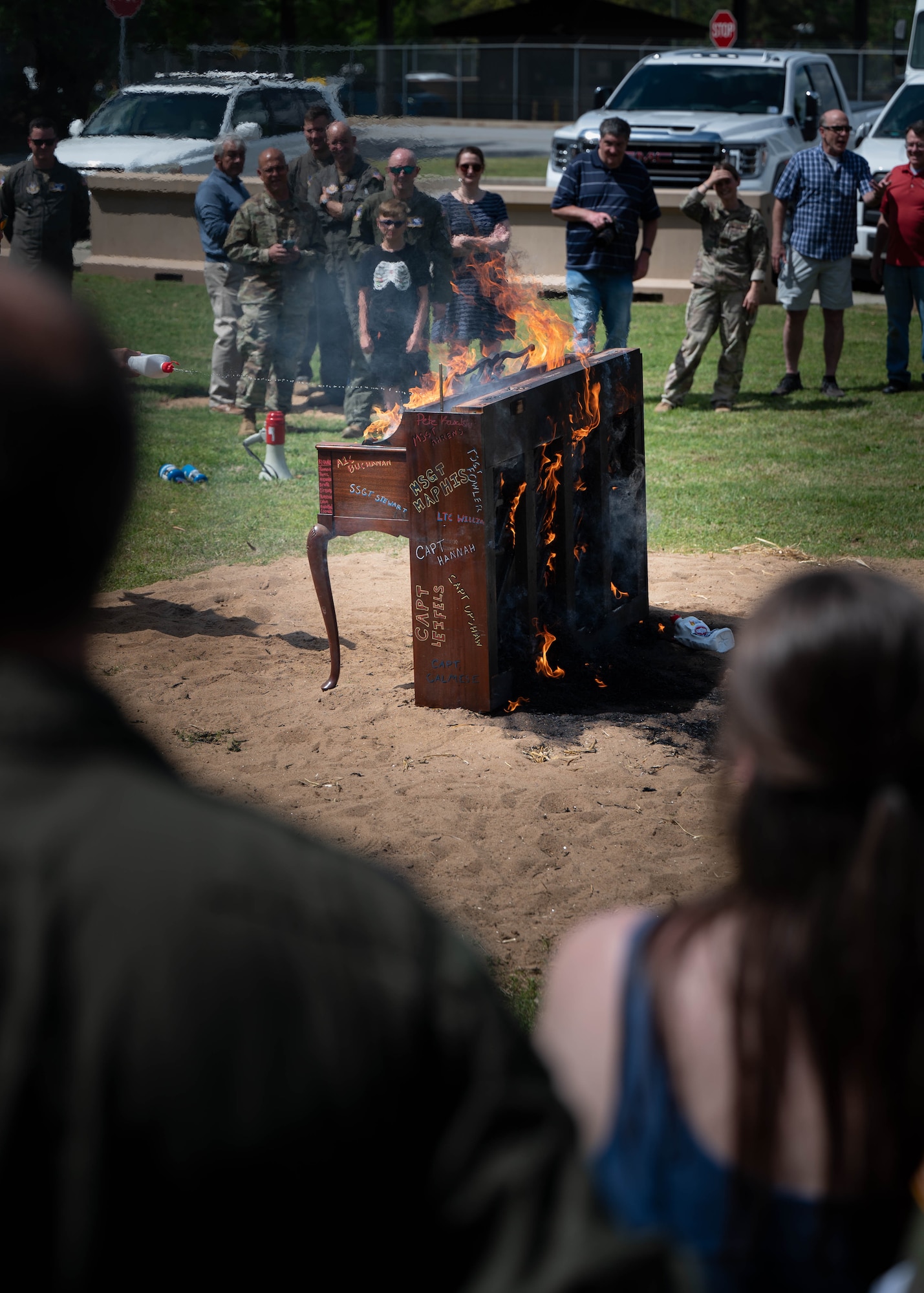 people look on as a piano burns