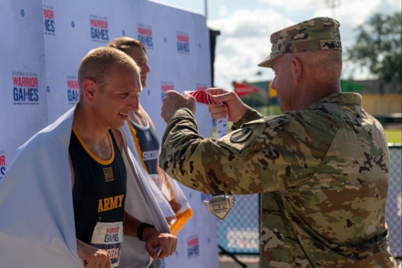 U.S. Army Maj. Gen. John D. Kline, Commanding General of the United States Army Center for Initial Military Training, United States Army Training and Doctrine Command, right, presents the silver medal to Sgt. 1st Class Jeffrey Peters