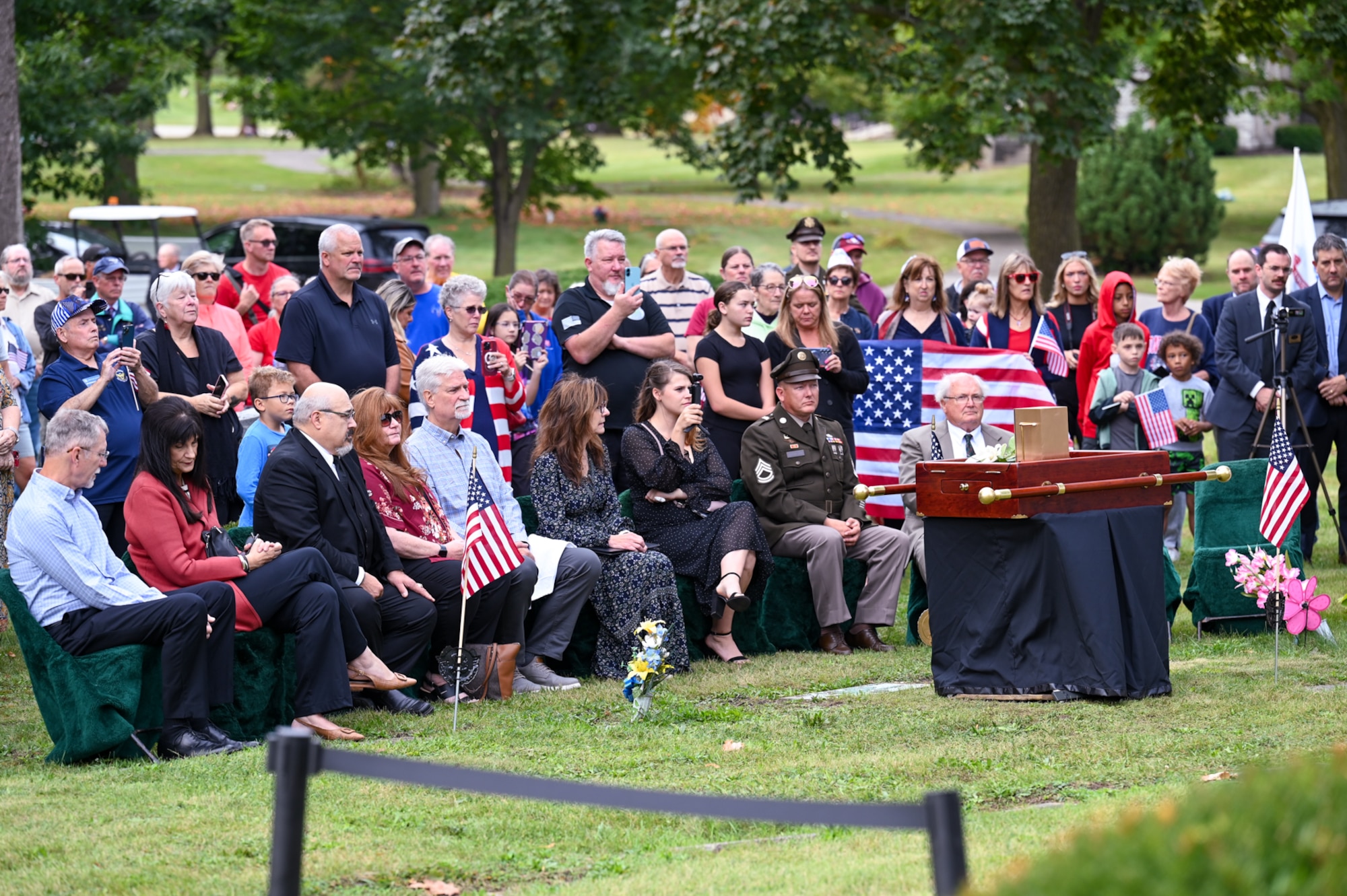 Rows of people attend a burial