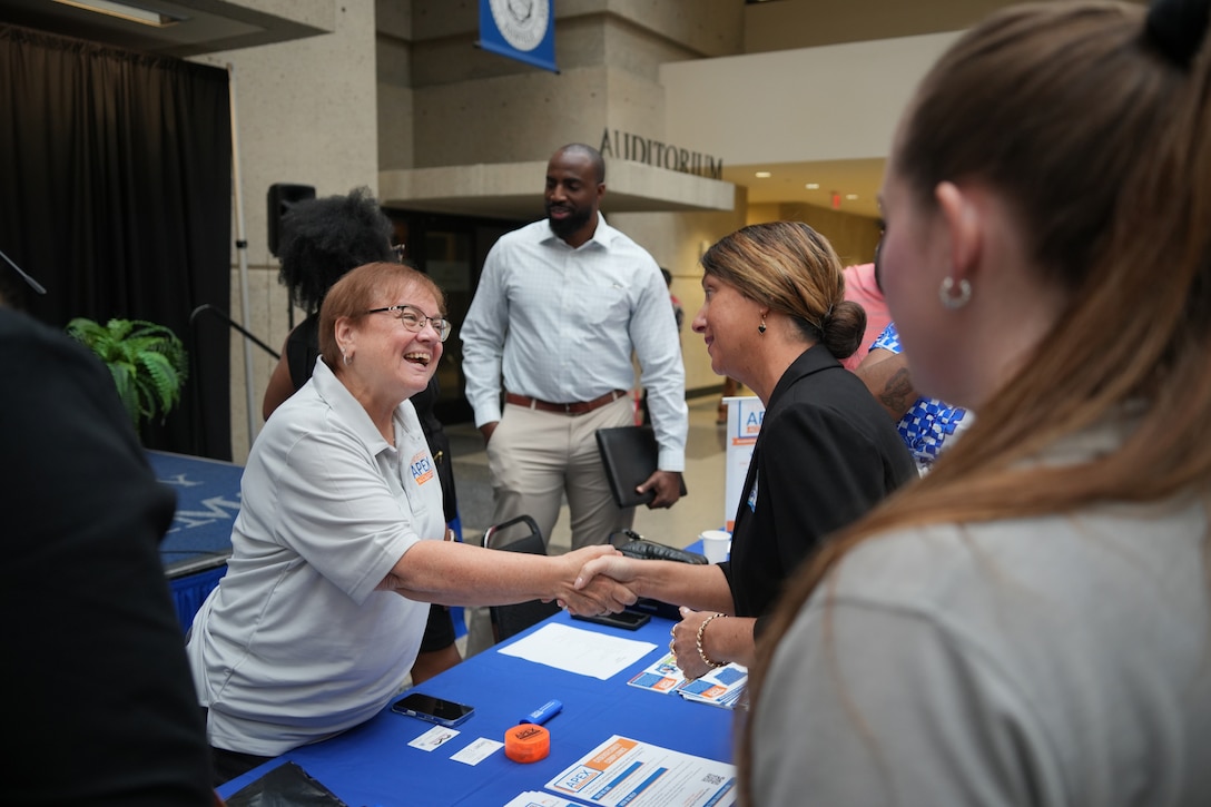 Bridget Passatore, contract officer for the U.S. Army Corps of Engineers Nashville District, greets Debbie Barber, an APEX counselor for the state of Tennessee, as Alison Abernathy, a contracting officer with the Nashville District, looks on. (USACE Photo by Noe Gonzalez)