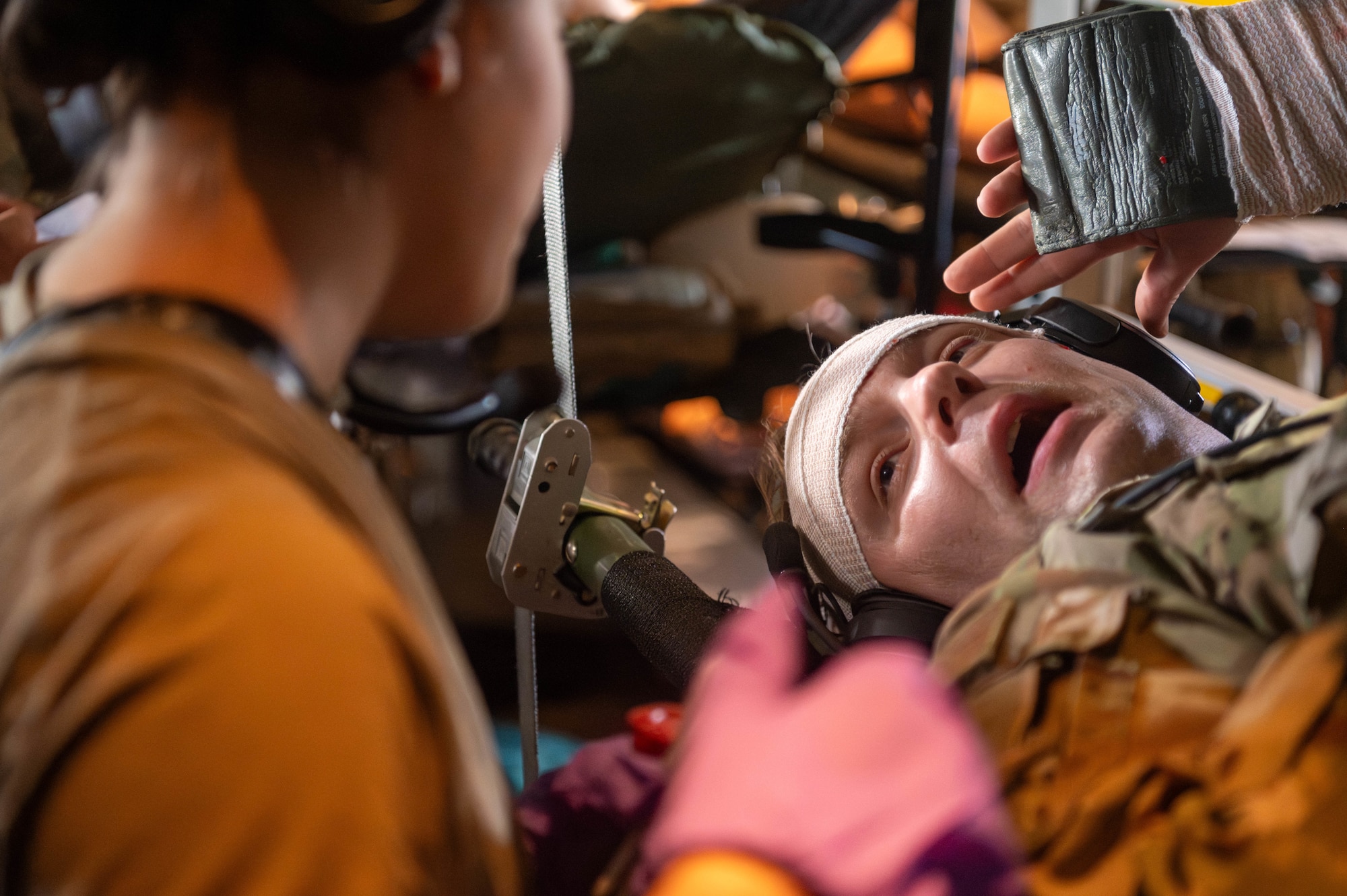 Air Force Staff Sgt. Dustin Hibler, 375th Aeromedical Evacuation Squadron technician, signals to a medical provider as a simulated casualty in a Theater Aeromedical Evacuation System exercise at Scott Air Force Base