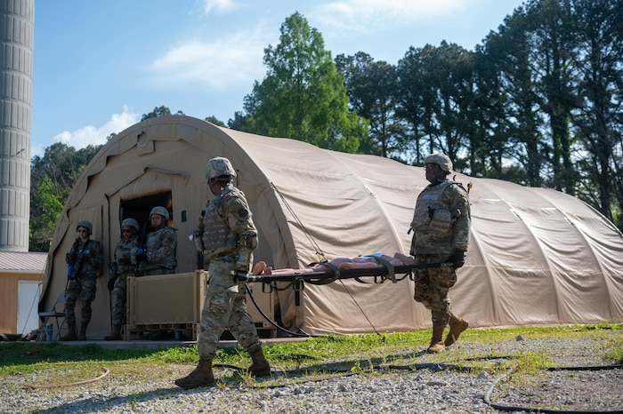 ​​Airmen carry a training mannequin during a Theater Aeromedical Evacuation System exercise at Scott Air Force Base