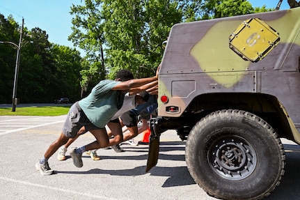 Participants take part pushing a Humvee during the Defenders challenge.