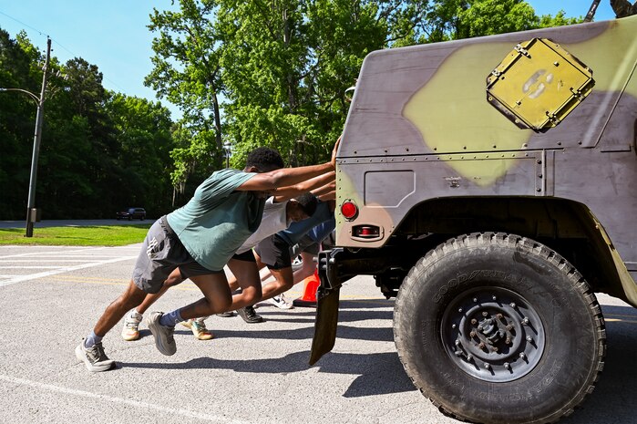 Participants take part pushing a Humvee during the Defenders challenge.
