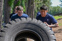 Participants flip a tractor tire during Defenders Challenge.