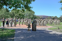 Joint Base Charleston leadership and Defenders from the 628th Security Forces Squadron render a salute during the National Anthem.