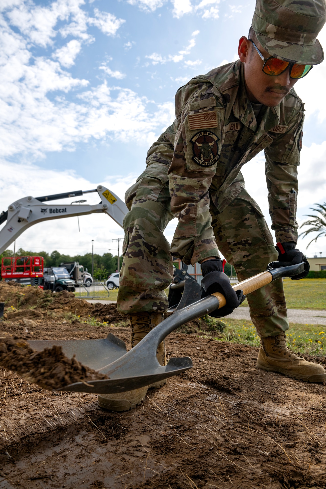 Airman 1st Class David Bui, 446th Civil Engineer Squadron pavement equipment apprentice, shovels dirt at Moron Air Base, Spain, on May 6, 2025.