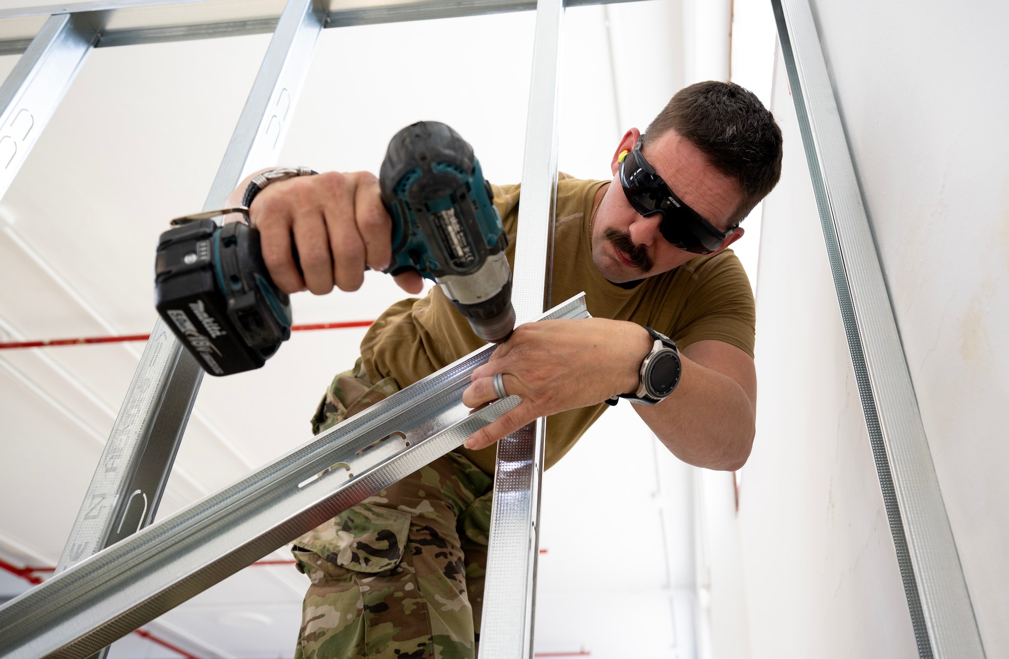 Tech. Sgt. Michael Rizzotti, 446th Civil Engineer Squadron structural NCOIC, screws frames together at Moron Air Base, Spain, on May 7, 2025.