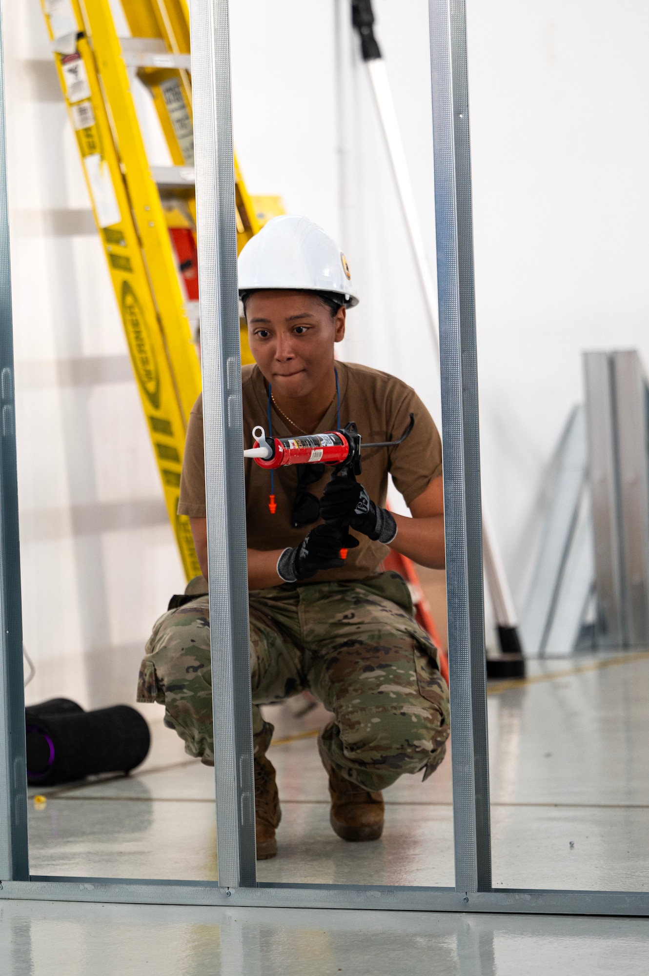 Staff Sgt. Jamie Boyd, 446th Civil Engineer Squadron pest management, squirts liquid nail on a frame at Moron Air Base, Spain, on May 8, 2025.
