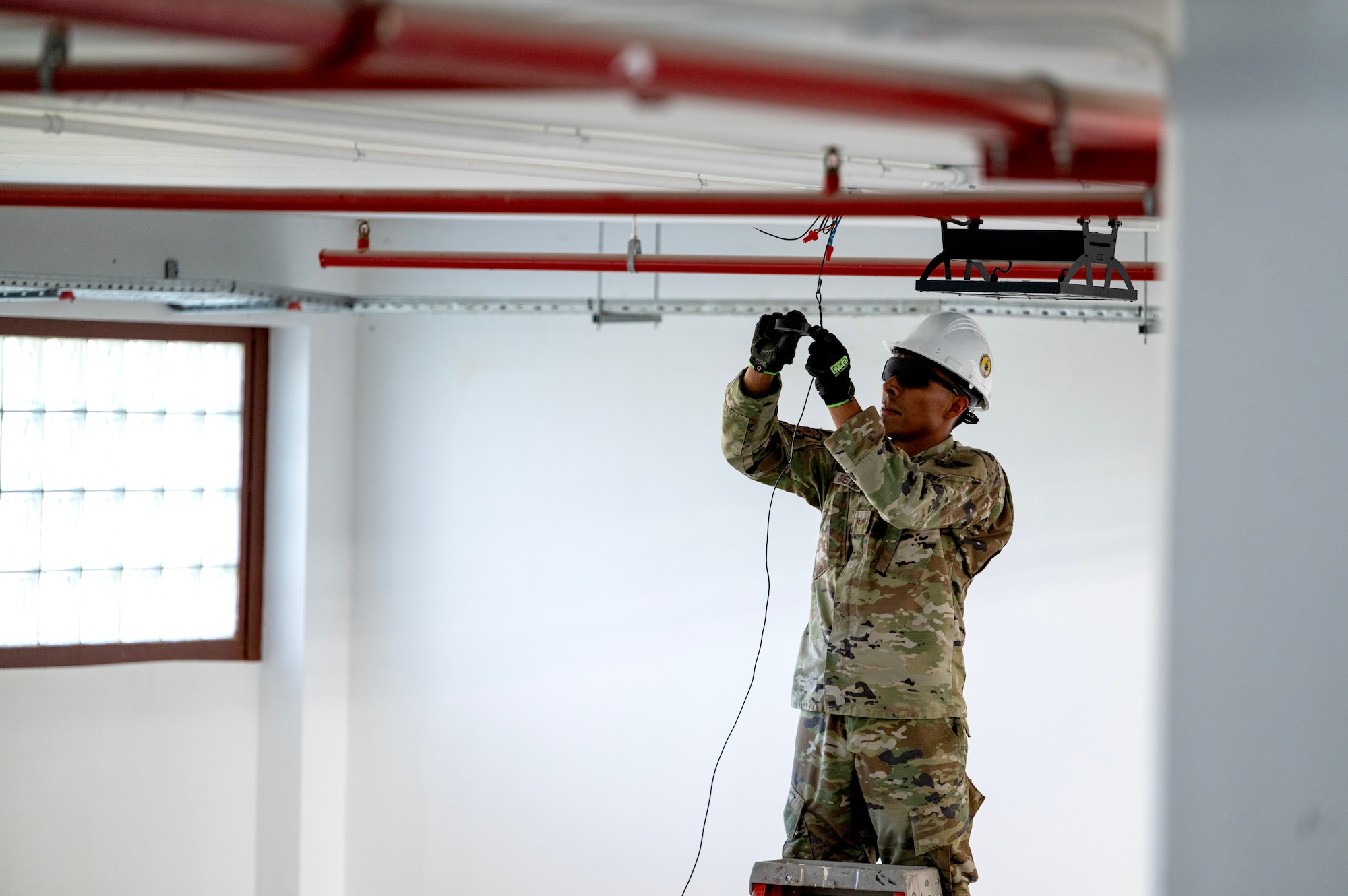 Senior Airman Alvarado Orellana, 446th Civil Engineer Squadron electrical systems technician, unscrews an electrical plate at Moron Air Base, Spain, on May 8, 2025.