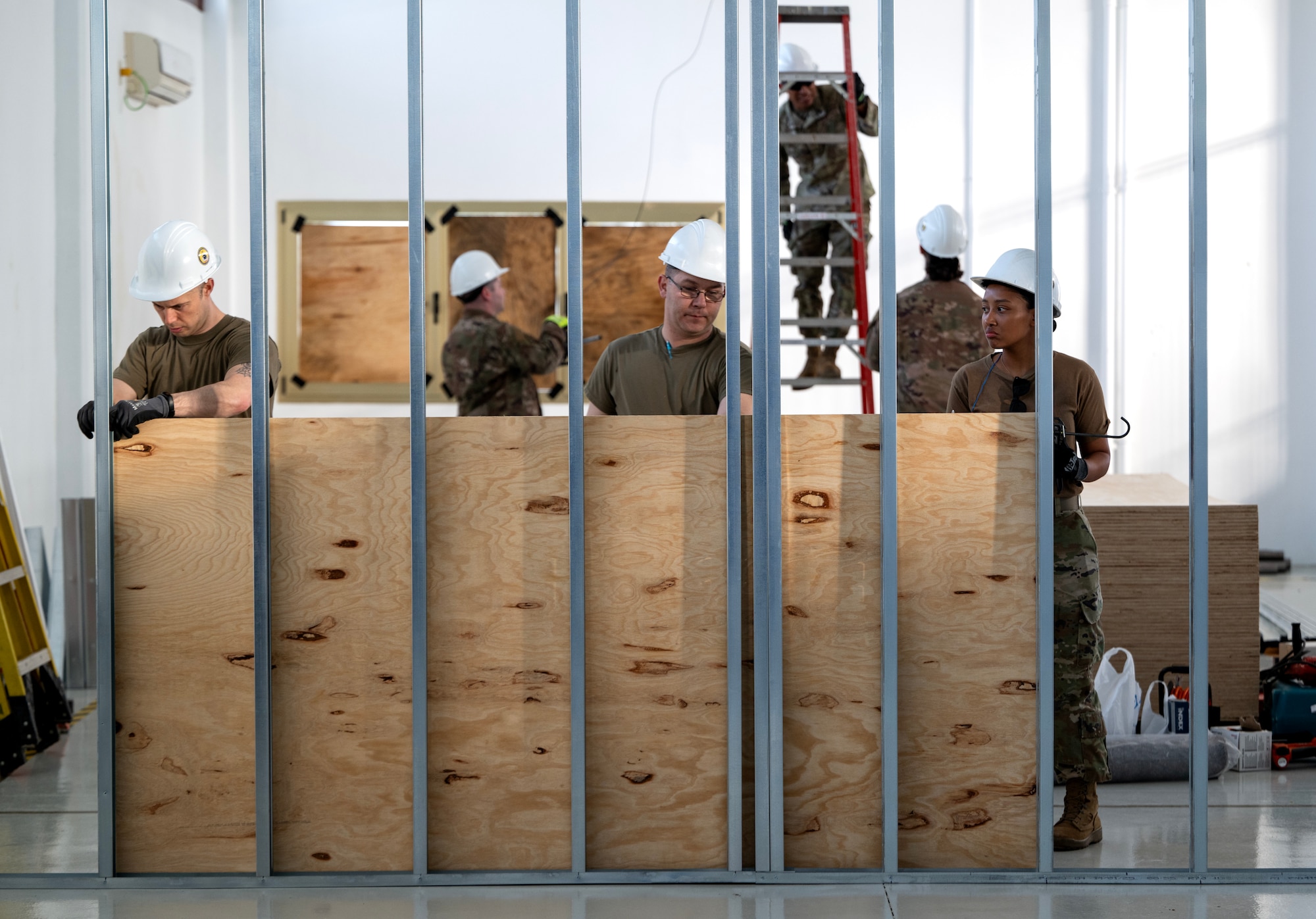 Airmen from the 446th Civil Engineer Squadron place wood panels on a structural frame at Moron Air Base, Spain, on May 8, 2025.