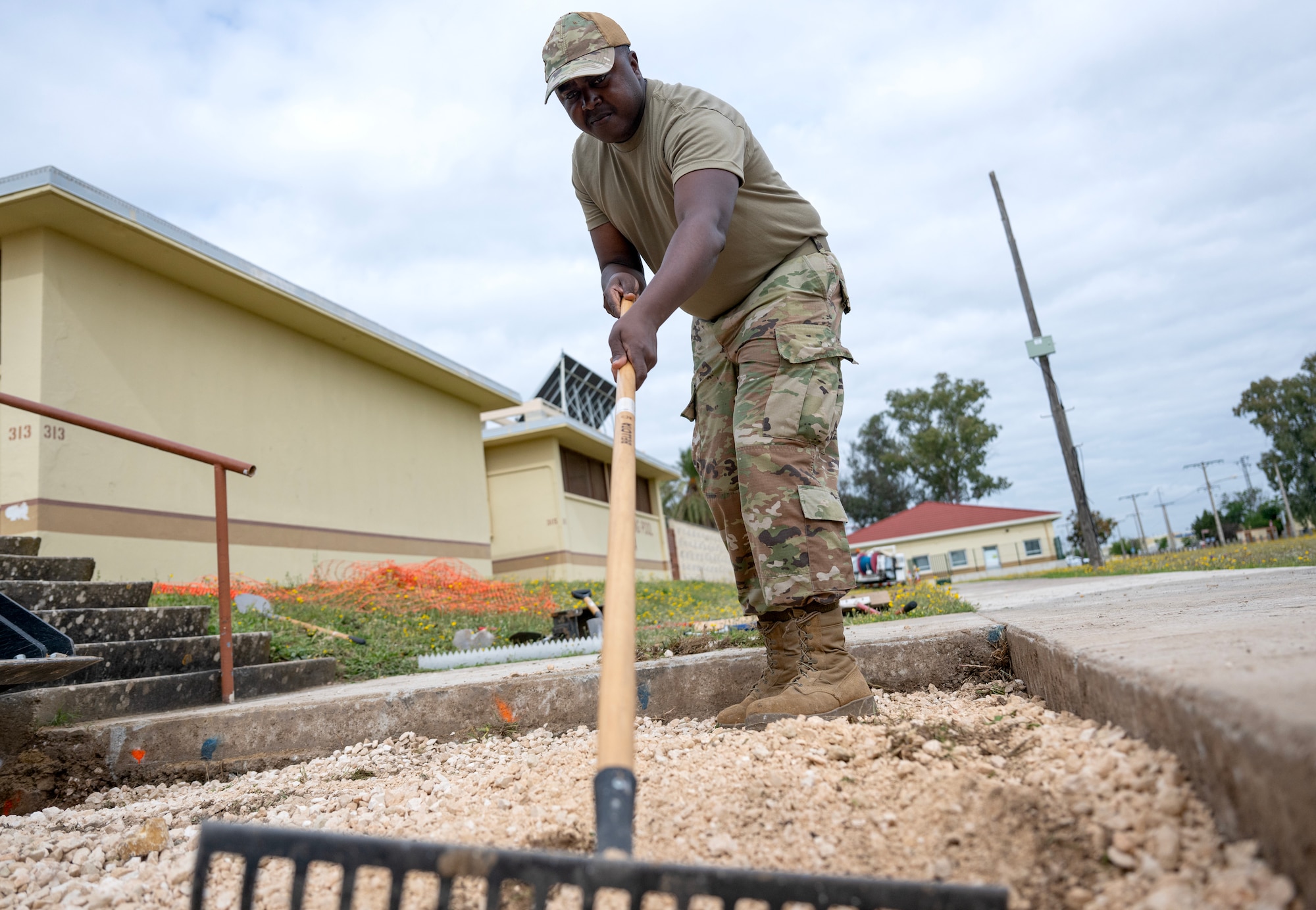 Senior Airman James Kamau, 446th Civil Engineer Squadron pavement and construction equipment journeyman, levels gravel to prep for a concrete pour on May 9, 2025, at Moron Air Base, Spain