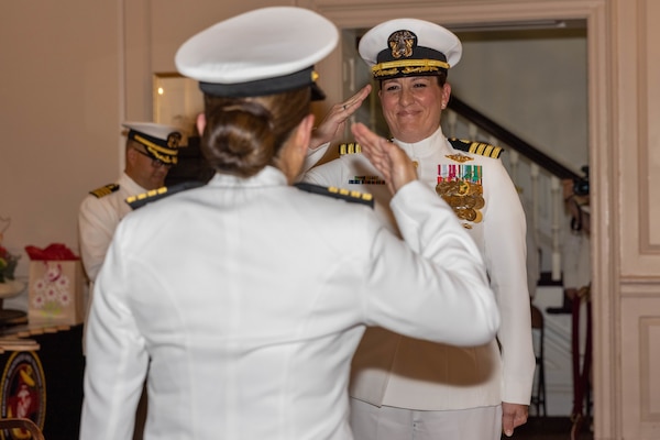 U.S. Navy Capt. Grace L. Key, outgoing commanding officer of Navy Medicine Readiness and Training Command Quantico, salutes Capt. Brookes Williams, incoming commanding officer of NMRTCQ, during a change of command ceremony at Harry Lee Hall on Marine Corps Base Quantico, Virginia, May 22, 2025. During the ceremony Key was relieved by Williams. (U.S. Marine Corps Photo by Lance Cpl. Harleigh Faulk)