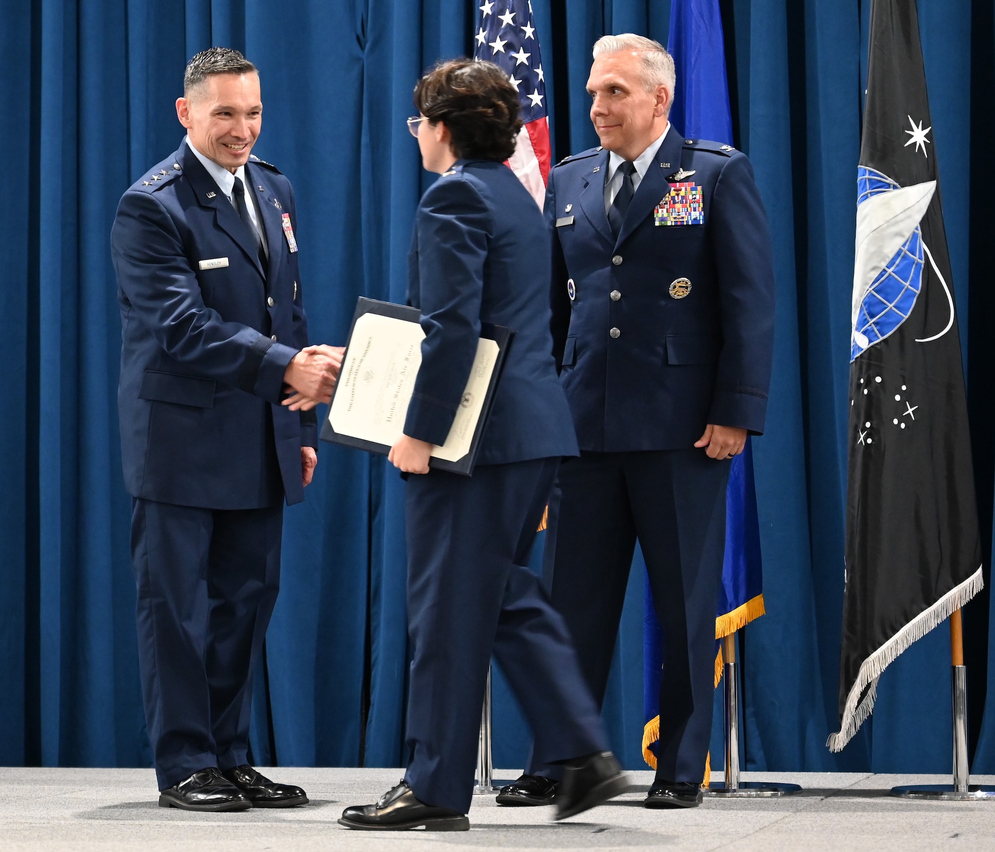 Cadet receives award on stage with Air Force leadership.