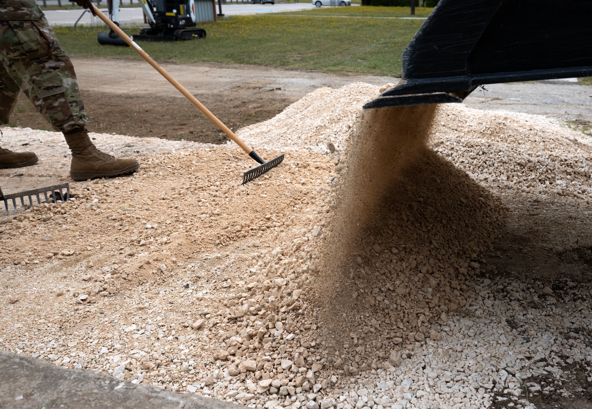 Dirt is dumped into a pile while an Airman from the 446th Civil Engineer Squadron levels it at Moron Air Base, Spain, on May 9, 2025.