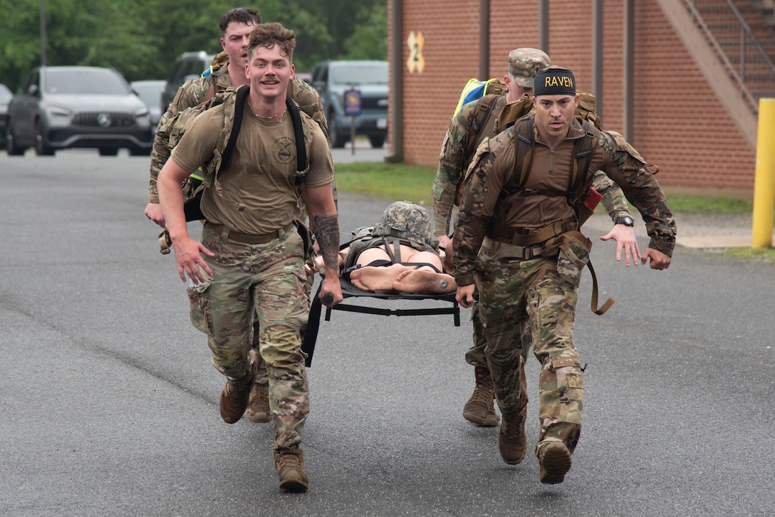 Defenders from the 316th Security Forces Group carry a training dummy on a litter to the final checkpoint during the Warrior Challenge at Joint Base Andrews, Md., May 14, 2025. The event was held in recognition of National Police Week. (U.S. Air Force photo by Patrick Griffith)
