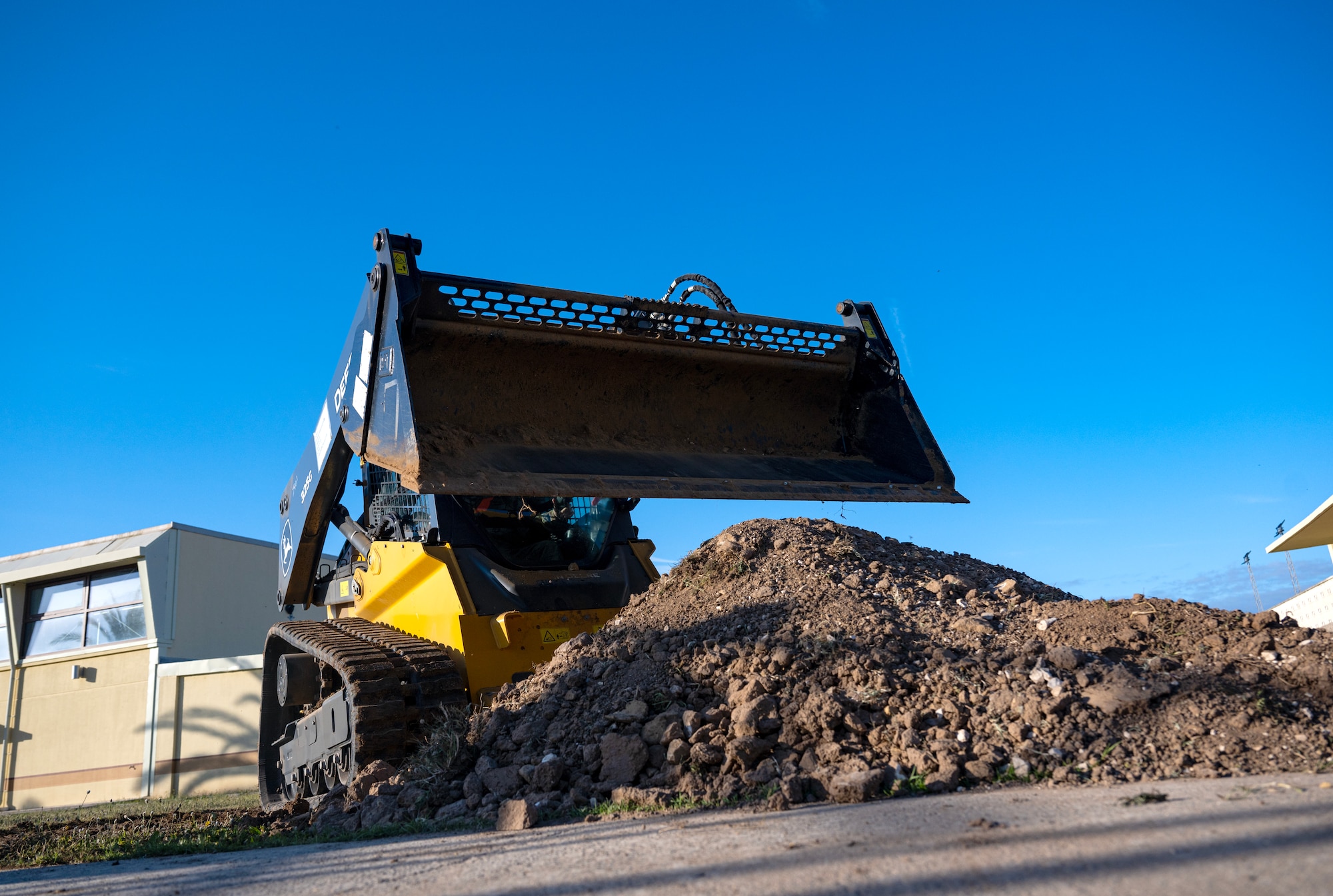 A crawl loader scoops dirt at Moron Air Base, Spain, on May 6, 2025.