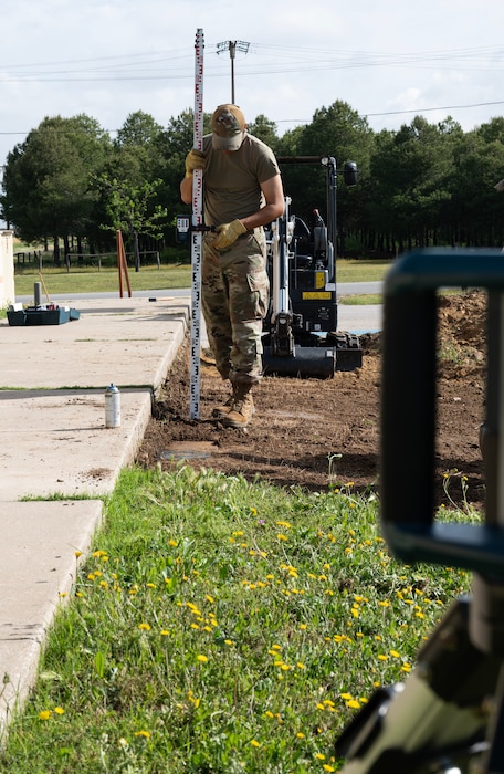 Senior Airman Kyu Wintersteen, 446th Civil Engineer Squadron pavement and construction equipment, checks the level of the ground at Moron Air Base, Spain, on May 6, 2025.