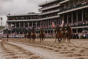 1st Infantry Division's Commanding General's Mounted Color Guard charges off the field after performing the Passing of the Colors during the Kentucky Derby, on May 3, 2025. This is the first year that U.S. Army horses have been invited to perform on track grounds since the Derby’s beginnings in 1875. (U.S. Army photo by Sgt. Tyler Selige)
