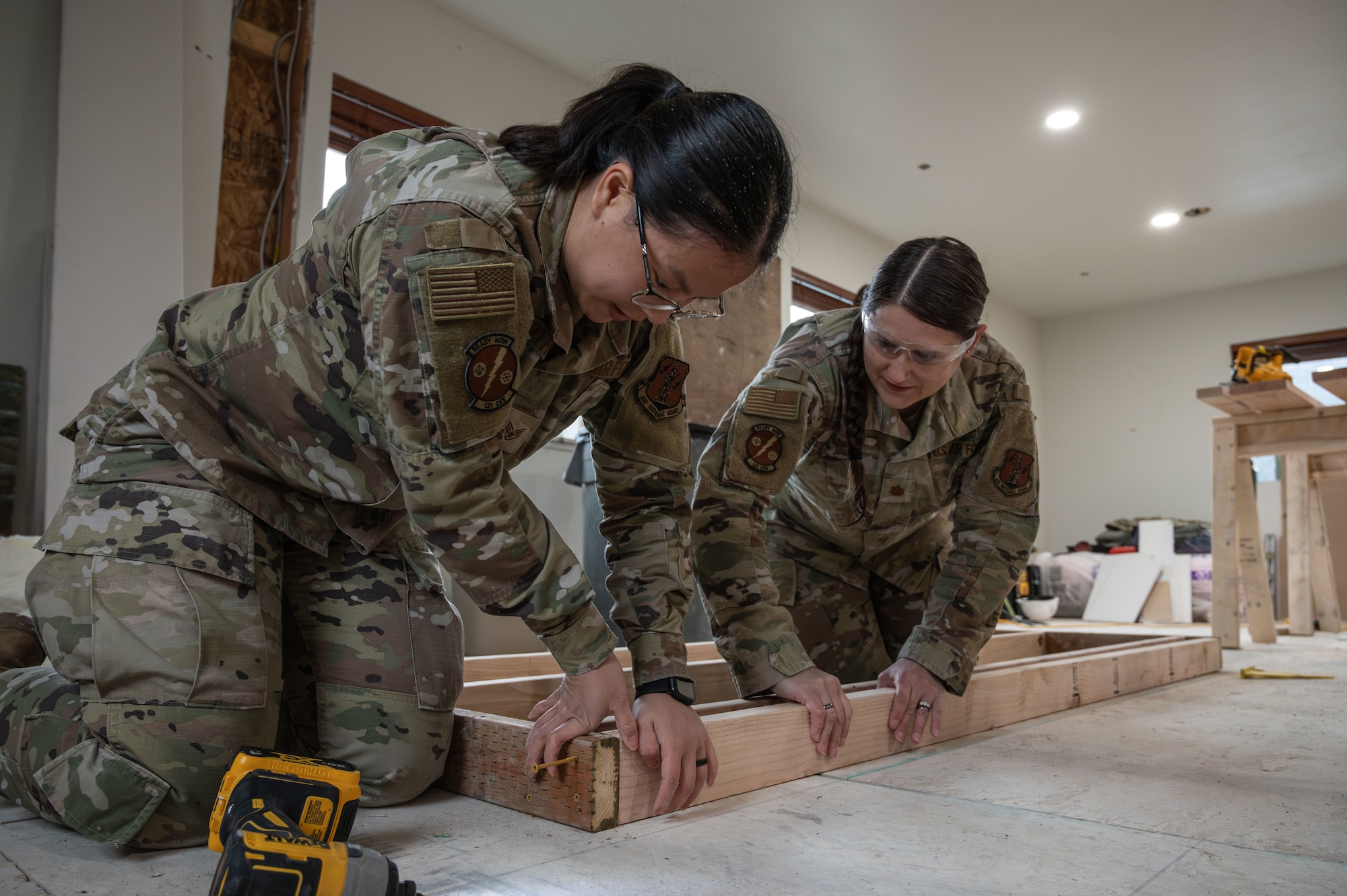 Maj. Star Loftus, 131st Civil Engineer Squadron (CES) civil engineer officer, assists Staff Sgt. Tess Woerther, structures journeyman, with the construction of a wall during a deployment for training in Seward, Alaska, April 29, 2025. 131st CES Airmen deployed to Alaska as part of an ongoing partnership with the Seward Military Resort, which allows military units to train while updating structures and infrastructure on location. (U.S. Air National Guard photo by Senior Airman Kelly C. Ferguson)