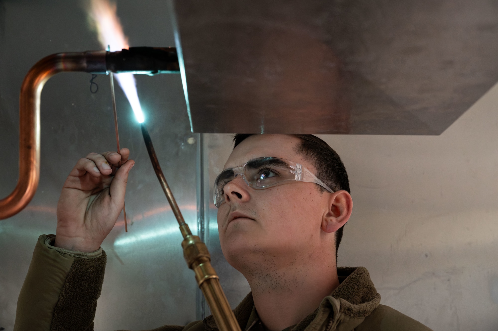 Airman 1st Class Tristan Ash, 131st Civil Engineer Squadron (CES) heating, ventilation and air conditioning trainee, solders a pipe during a deployment for training in Seward, Alaska, April 29, 2025. 131st CES Airmen deployed to Alaska as part of an ongoing partnership with the Seward Military Resort, which allows military units to train while updating structures and infrastructure on location. (U.S. Air National Guard photo by Senior Airman Kelly C. Ferguson)