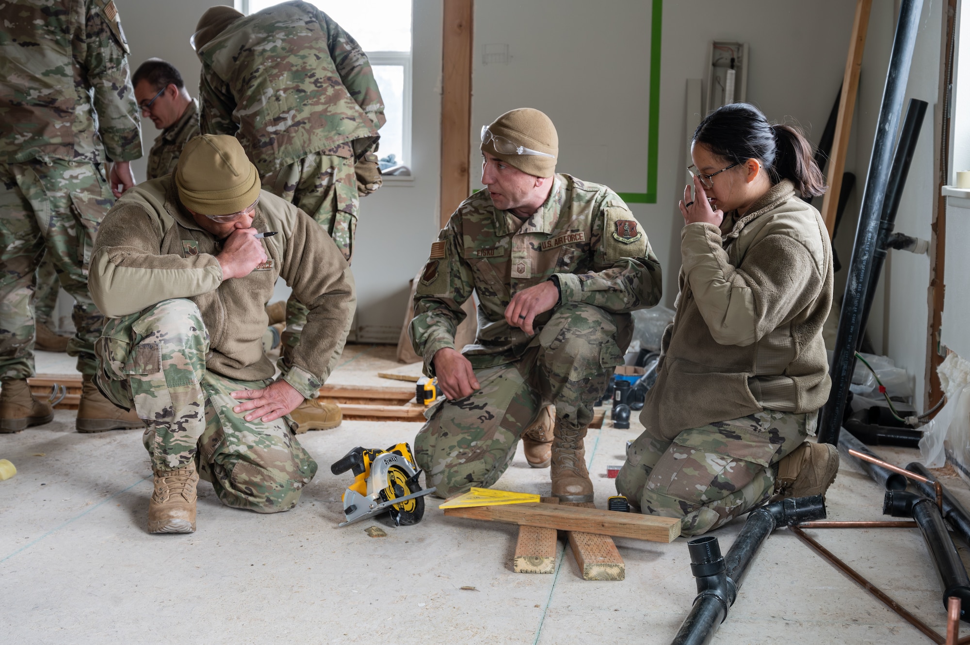 Master Sgt. Erik Fisko, 131st Civil Engineer Squadron (CES) structures supervisor, demonstrates on proper circular saw use to Tech. Sgt. Adrian Doss and Staff Sgt. Tess Woerther, structures journeymen, during a deployment for training in Seward, Alaska, April 23, 2025. 131st CES Airmen deployed to Alaska as part of an ongoing partnership with the Seward Military Resort, which allows military units to train while updating buildings and infrastructure on location. (U.S. Air National Guard photo by Senior Airman Kelly C. Ferguson)