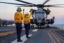 Aviation Boatswain’s Mate (Handling) 3rd Class Lauren Bryan, from Victorville, California, right, and Aviation Boatswain’s Mate (Handling) Airman, JuanDiego Navarro, left, from Puerto Rico, both assigned to the forward-deployed amphibious assault ship USS America (LHA 6), direct a CH-53E Super Stallion helicopter, from the 31st Marine Expeditionary Unit (MEU) Air Combat Element (ACE) to take off from the flight deck while conducting flight operations in the Philippine Sea, May 22. The America, lead ship of the America Amphibious Ready Group, is operating in the U.S. 7th Fleet area of operations. U.S. 7th Fleet is the U.S. Navy’s largest forward-deployed numbered fleet, and routinely interacts and operates with allies and partners in preserving a free and open Indo-Pacific region. (U.S. Navy photo by Mass Communication 3rd Class Kenneth Melseth)