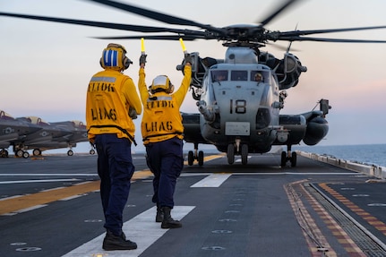 Aviation Boatswain’s Mate (Handling) 3rd Class Lauren Bryan, from Victorville, California, right, and Aviation Boatswain’s Mate (Handling) Airman, JuanDiego Navarro, left, from Puerto Rico, both assigned to the forward-deployed amphibious assault ship USS America (LHA 6), direct a CH-53E Super Stallion helicopter, from the 31st Marine Expeditionary Unit (MEU) Air Combat Element (ACE) to take off from the flight deck while conducting flight operations in the Philippine Sea, May 22. The America, lead ship of the America Amphibious Ready Group, is operating in the U.S. 7th Fleet area of operations. U.S. 7th Fleet is the U.S. Navy’s largest forward-deployed numbered fleet, and routinely interacts and operates with allies and partners in preserving a free and open Indo-Pacific region. (U.S. Navy photo by Mass Communication 3rd Class Kenneth Melseth)