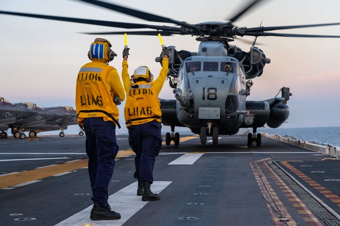 Aviation Boatswain’s Mate (Handling) 3rd Class Lauren Bryan, from Victorville, California, right, and Aviation Boatswain’s Mate (Handling) Airman, JuanDiego Navarro, left, from Puerto Rico, both assigned to the forward-deployed amphibious assault ship USS America (LHA 6), direct a CH-53E Super Stallion helicopter, from the 31st Marine Expeditionary Unit (MEU) Air Combat Element (ACE) to take off from the flight deck while conducting flight operations in the Philippine Sea, May 22. The America, lead ship of the America Amphibious Ready Group, is operating in the U.S. 7th Fleet area of operations. U.S. 7th Fleet is the U.S. Navy’s largest forward-deployed numbered fleet, and routinely interacts and operates with allies and partners in preserving a free and open Indo-Pacific region. (U.S. Navy photo by Mass Communication 3rd Class Kenneth Melseth)