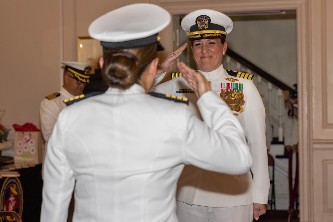 U.S. Navy Capt. Grace L. Key, outgoing commanding officer of Navy Medicine Readiness and Training Command Quantico, salutes Capt. Brookes Williams, incoming commanding officer of NMRTCQ, during a change of command ceremony at Harry Lee Hall on Marine Corps Base Quantico, Virginia, May 22, 2025. During the ceremony Key was relieved by Williams. (U.S. Marine Corps Photo by Lance Cpl. Harleigh Faulk)