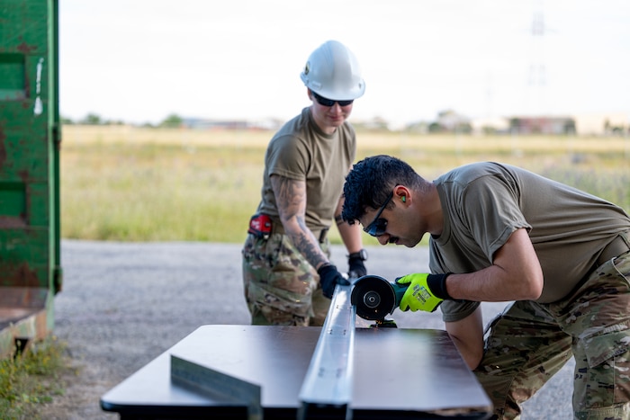 Senior Airmen Jessica Alcomendas and Eric Martinez-Pena, 446th Civil Engineer Squadron structural journeymen, cut pieces for a wall frame at Moron Air Base, Spain, on May 8, 2025.