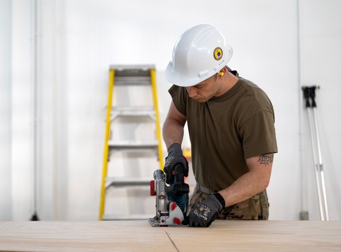 Staff Sgt. Michael Simon, 446th Civil Engineer Squadron HVAC NCOIC, cuts wood for a wall panel at Moron Air Base, Spain, on May 8, 2025.