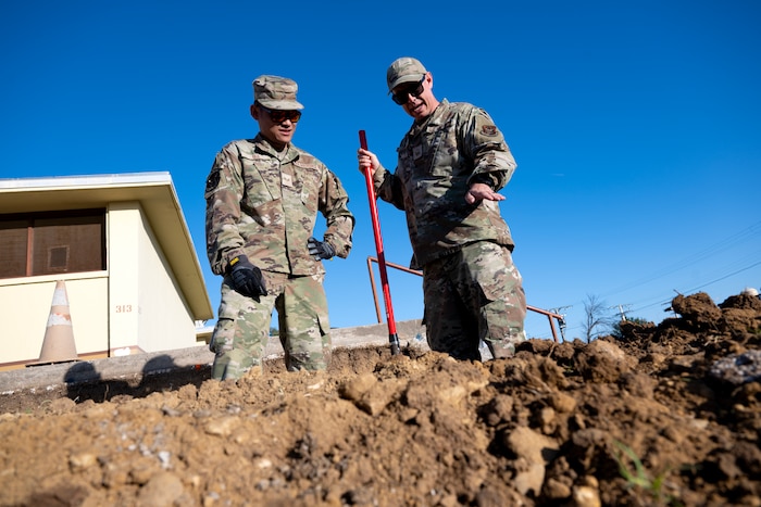 Master Sgt. Matthew Smith, 446th Civil Engineer Squadron pavement and construction equipment NCOIC, instructs Airman 1st Class David Bui, 446th CES pavement and construction equipment technician, on the best techniques fore ensuring an accurate slope at Moron Air Base, Spain, on May 6, 2025.
