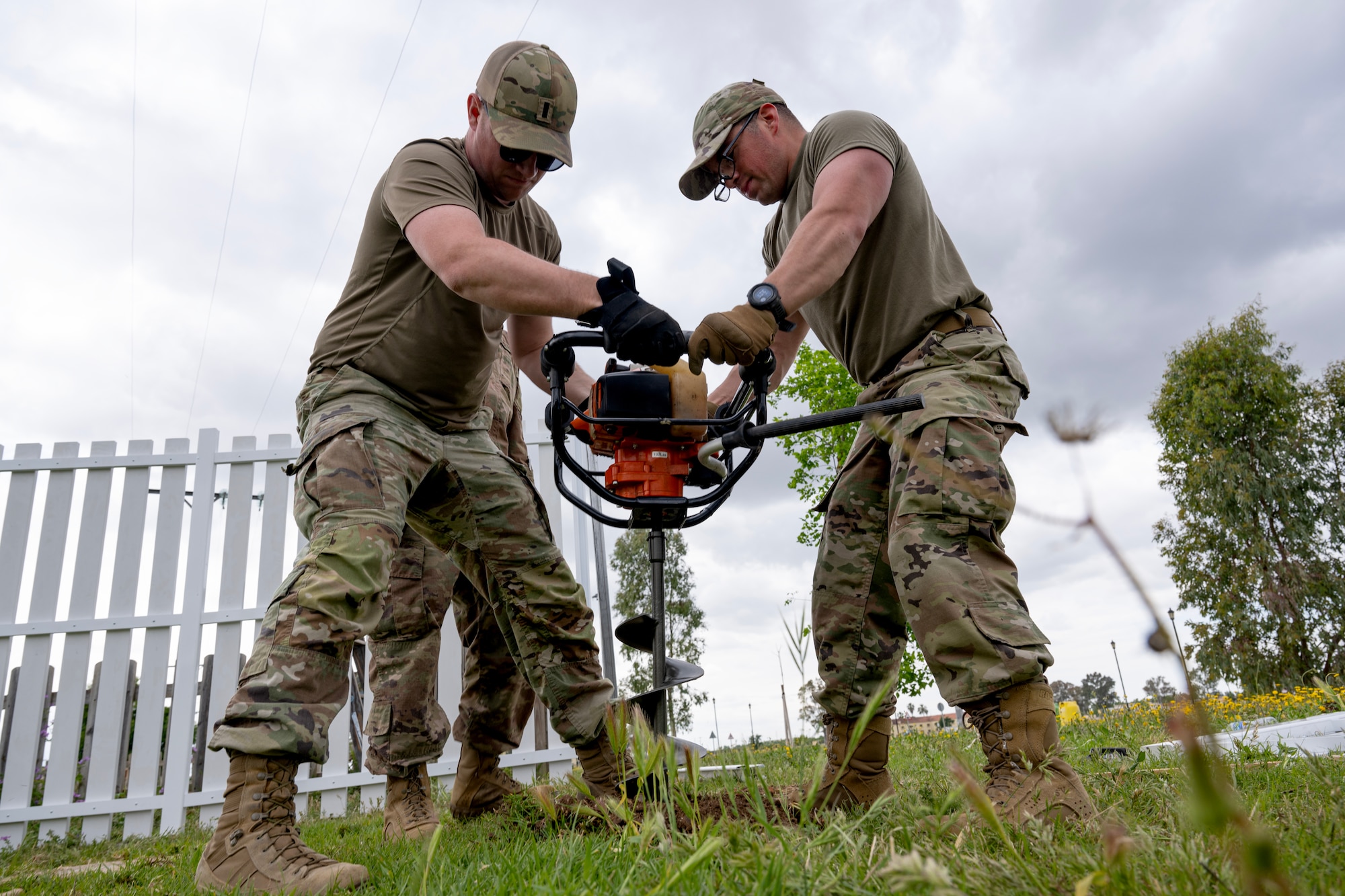 1st Lt. Joel Biamont, 446th Civil Engineer Squadron operations flight officer, and Senior Airman Eric Mendez, 446th Civil Engineer Squadron pest management, dig a hole for concrete for a fence post at Moron Air Base, Spain, on May 8, 2025.