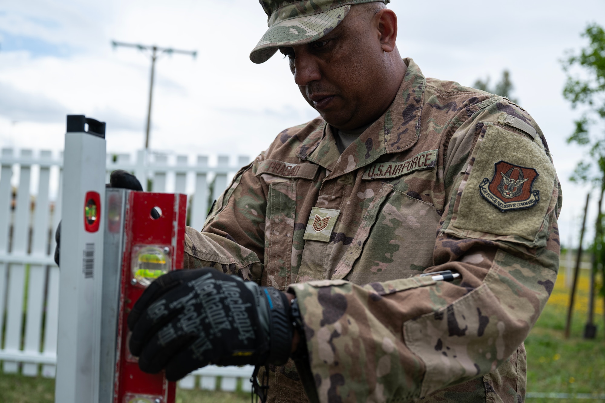 Tech. Sgt. Anuj Prasad, 446th Civil Engineer Squadron power production, checks the level of a fence post at Moron Air Base, Spain, on May 6, 2025.