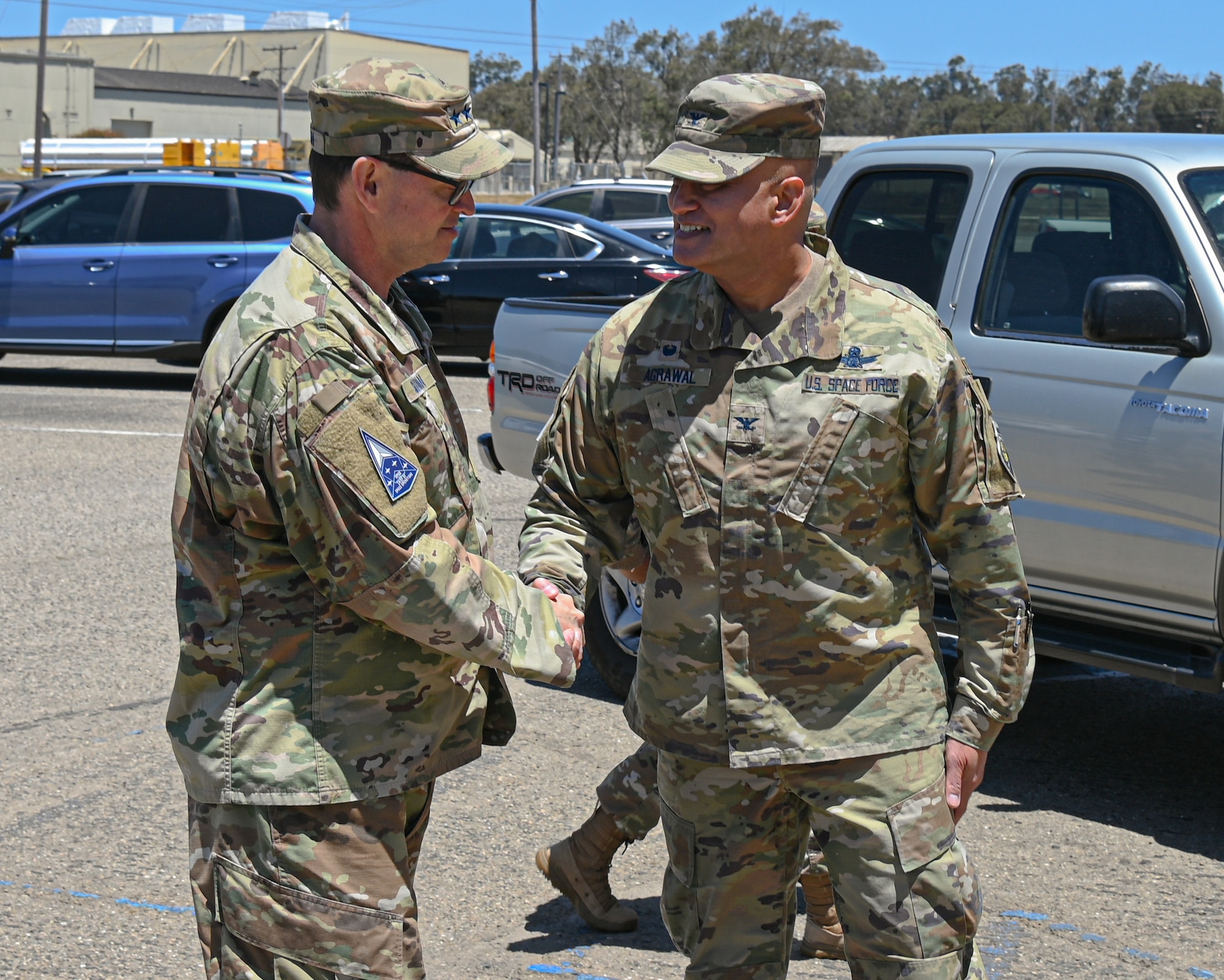 U.S. Space Force Chief of Space Operations Gen. Chance Saltzman, left, is greeted by Col. Raj Agriwal, Mission Delta 2 commander, right, by shaking hands during a visit to Vandenberg Space Force Base.