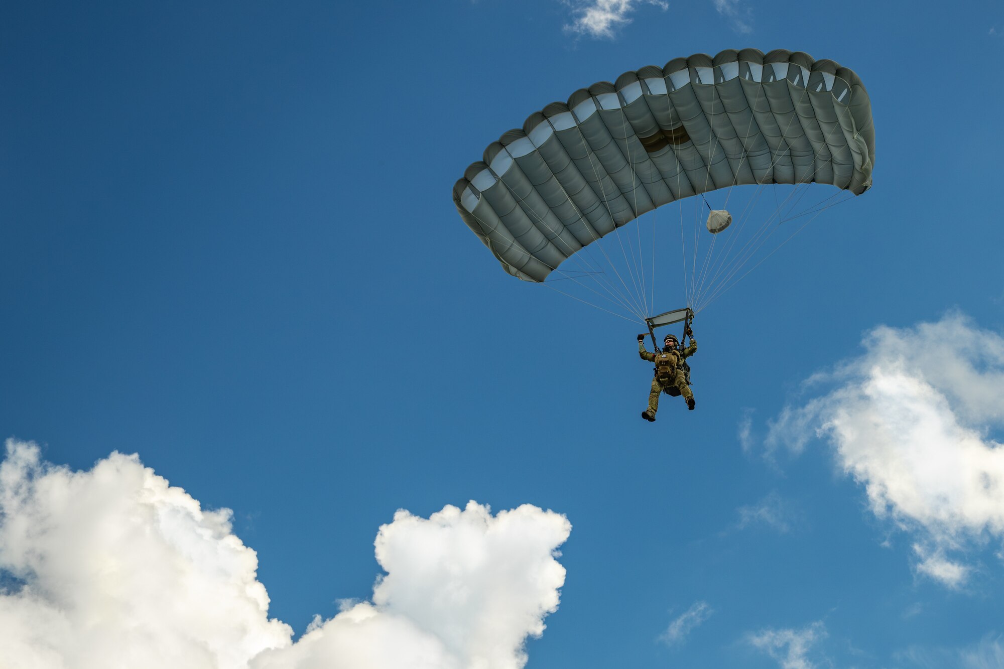 A combat controller from the Kentucky Air National Guard’s 123rd Special Tactics Squadron parachutes into Barkley Regional Airport in Paducah, Ky., May 13, 2025, from a C-130J Super Hercules aircraft in support of Exercise Grindstone, a three-day earthquake-response scenario staged in the New Madrid Seismic Zone, the most active seismic area in the Eastern United States. The Airmen conducted an assessment of airfield operability and provided air traffic control for follow-on aircraft bringing troops, cargo and equipment needed to establish an aerial port for relief operations. (U.S. Air National Guard photo by Dale Greer)
