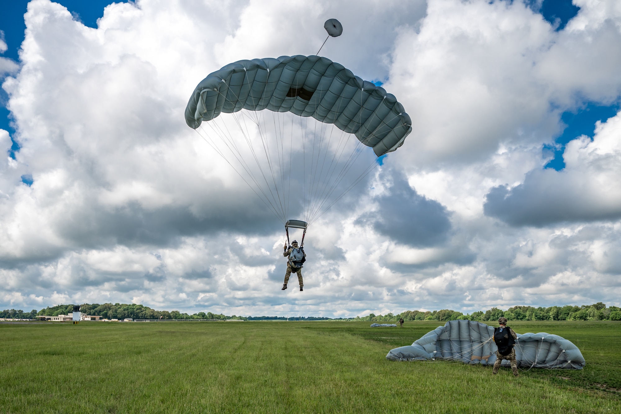 A combat controller from the Kentucky Air National Guard’s 123rd Special Tactics Squadron parachutes into Barkley Regional Airport in Paducah, Ky., May 13, 2025, from a C-130J Super Hercules aircraft in support of Exercise Grindstone, a three-day earthquake-response scenario staged in the New Madrid Seismic Zone, the most active seismic area in the Eastern United States. The Airmen conducted an assessment of airfield operability and provided air traffic control for follow-on aircraft bringing troops, cargo and equipment needed to establish an aerial port for relief operations. (U.S. Air National Guard photo by Dale Greer)