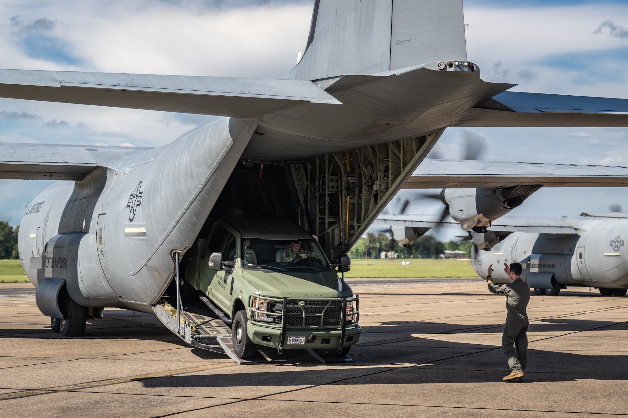 A loadmaster from the Kentucky Air National Guard’s 165th Airlift Squadron, directs the offloading of truck from a C-130J Super Hercules aircraft at Barkley Regional Airport in Paducah, Ky., May 13, 2025, in support of Exercise Grindstone, a three-day earthquake-response scenario staged in the New Madrid Seismic Zone. Paducah lies within the zone, the most active seismic area in the Eastern United States, and could serve as an air hub in the event of an large-scale earthquake  (U.S. Air National Guard photo by Dale Greer)