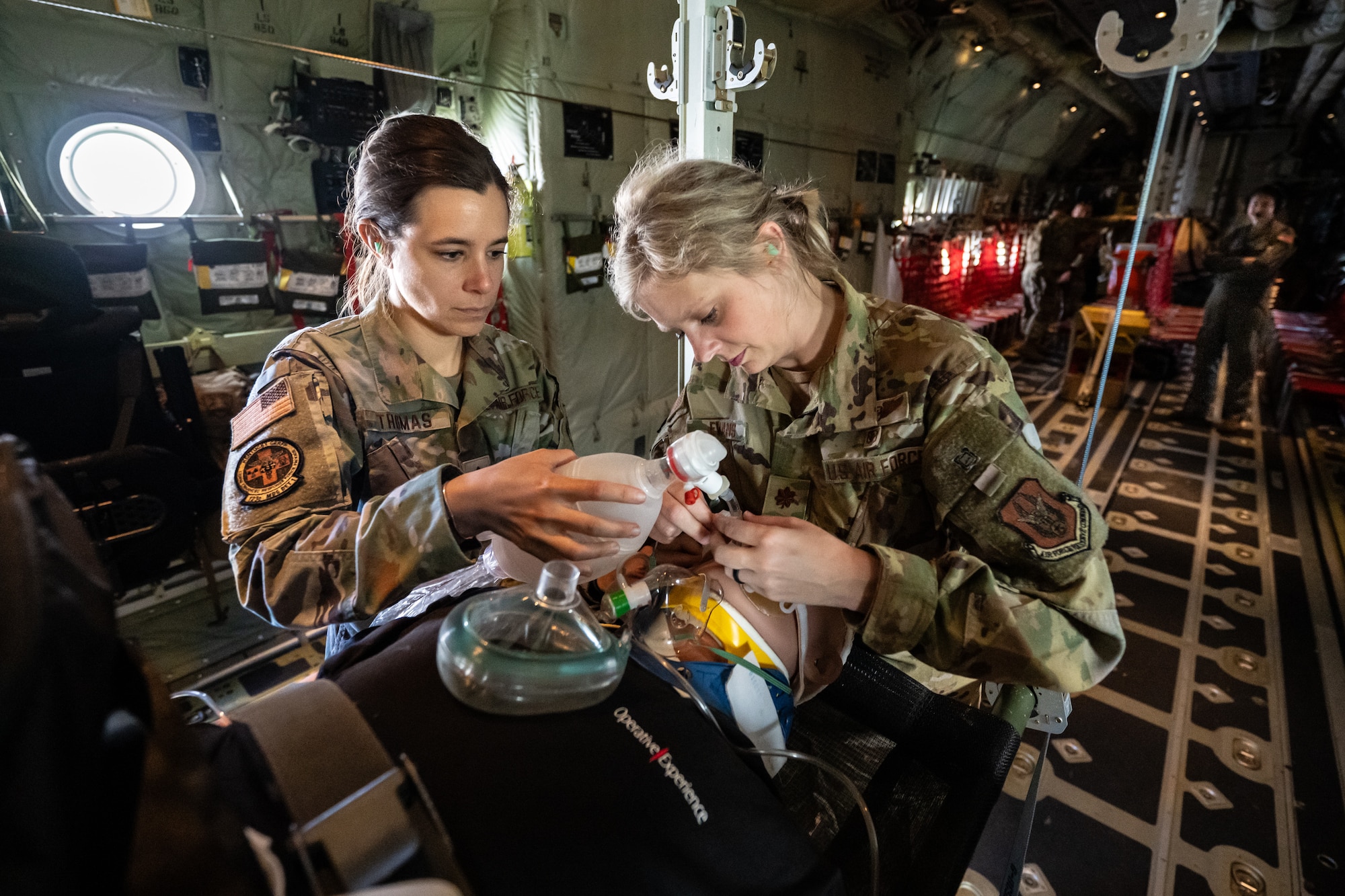 Maj. Alena Thomas, left, a physician assistant, and Maj. Felicia Evans, a nurse — both members of a Critical Care Air Transport Team from the 123rd Medical Group — stabilize a simulated patient May 14, 2025, during a flight from Murray to Paducah, Ky., aboard a Kentucky Air National Guard C-130J Super Hercules aircraft. The event was part of Exercise Grindstone, a major earthquake-response simulation staged in the New Madrid Seismic Zone, the most active seismic area in the Eastern United States. (U.S. Air National Guard photo by Dale Greer)