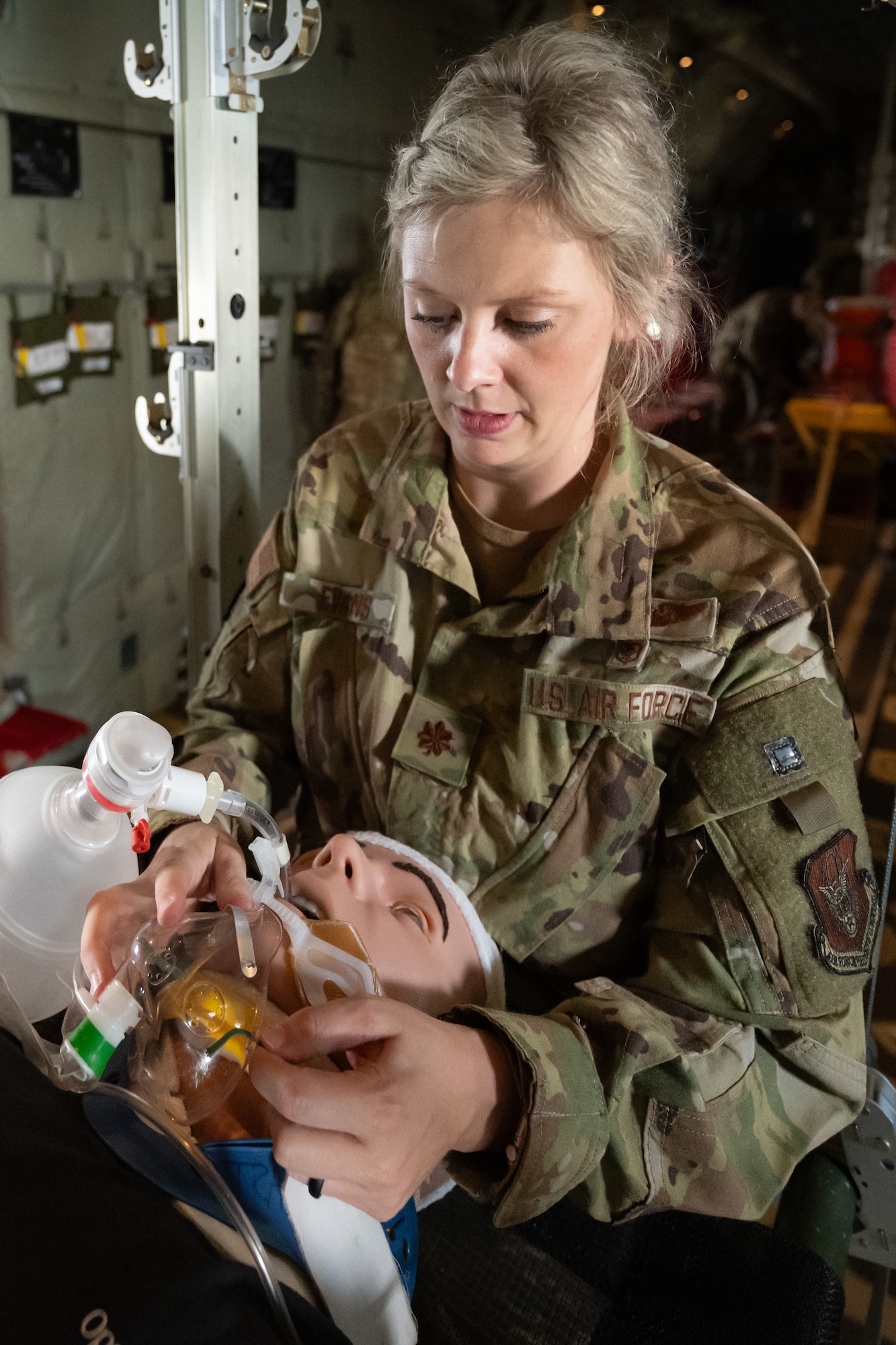 Maj. Felicia Evans, a nurse from the 123rd Medical Group, stabilizes a simulated patient May 14, 2025, during a flight from Murray to Paducah, Ky., aboard a Kentucky Air National Guard C-130J Super Hercules aircraft. The event was part of Exercise Grindstone, a major earthquake-response simulation staged in the New Madrid Seismic Zone, the most active seismic area in the Eastern United States. (U.S. Air National Guard photo by Dale Greer)