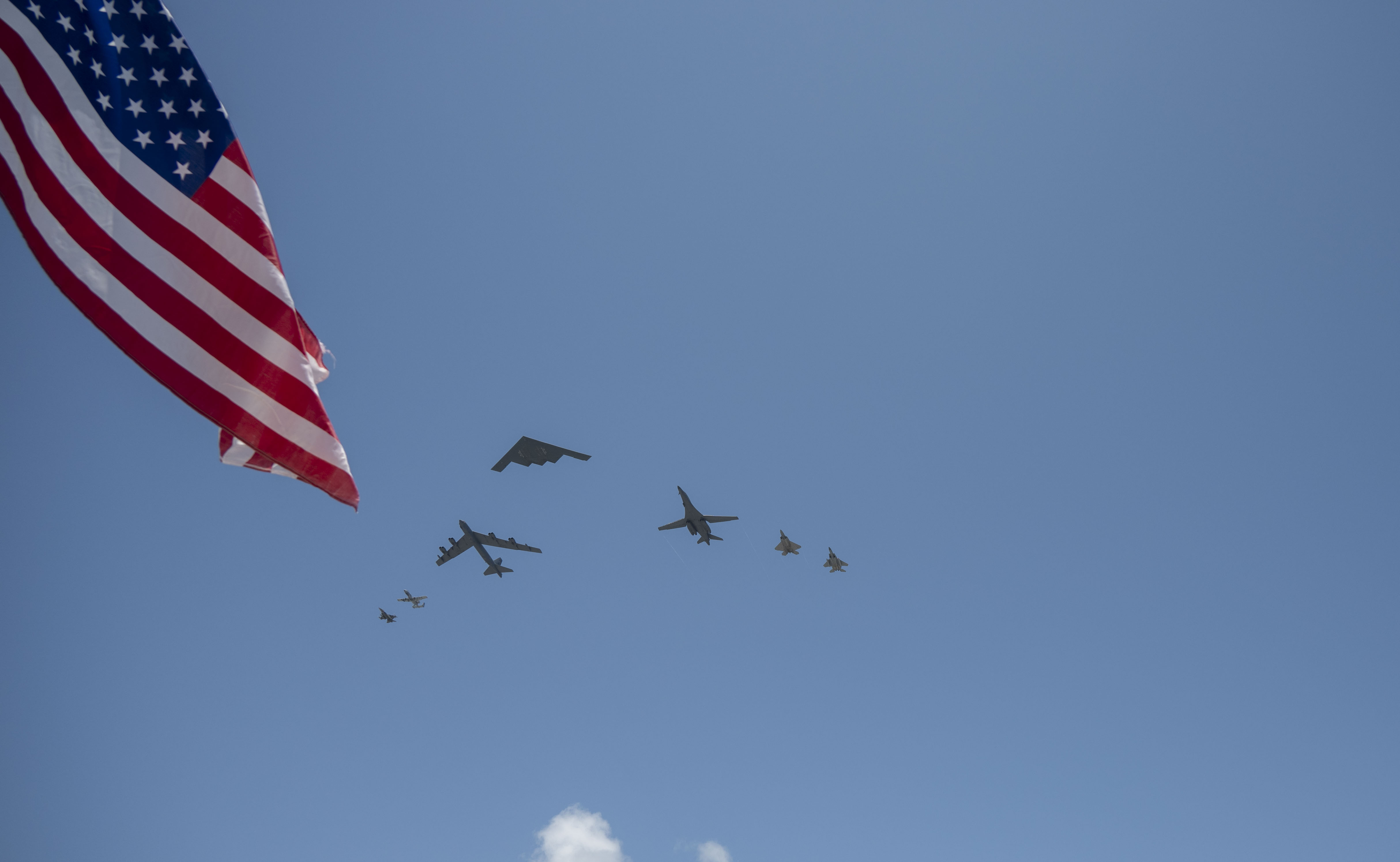 Formation of 7 aircraft with flag on the left