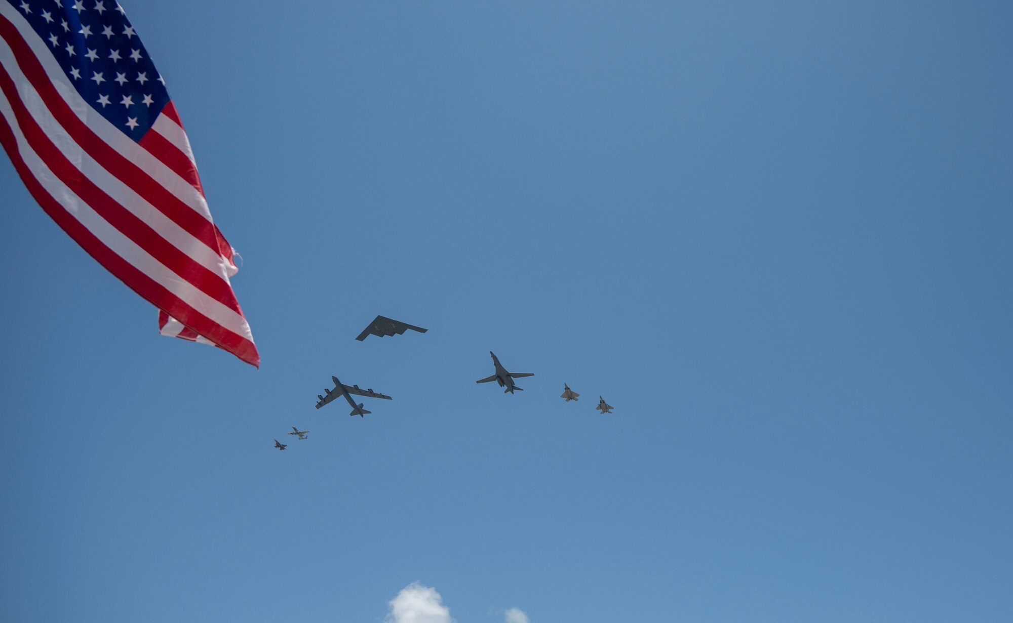 Formation of 7 aircraft with flag on the left