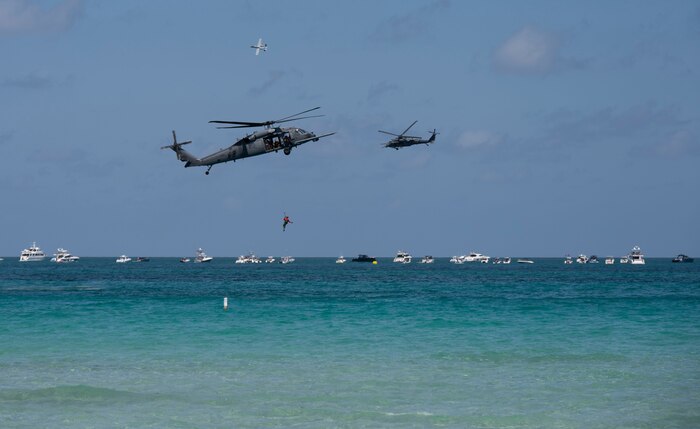 two helicopters hovering over the ocean
