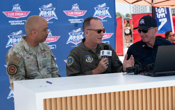 Three men sitting at a table for a media interview